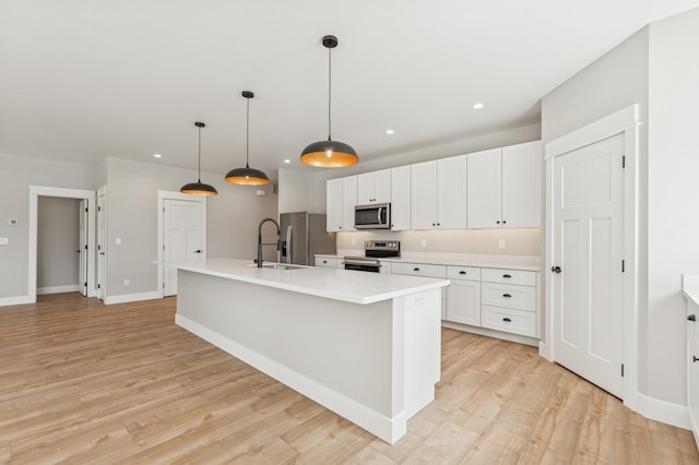 268 Landing Ln, Kalispell, MT 59901 - kitchen with stainless steel appliances, light countertops, an island with sink, a sink, and white cabinets