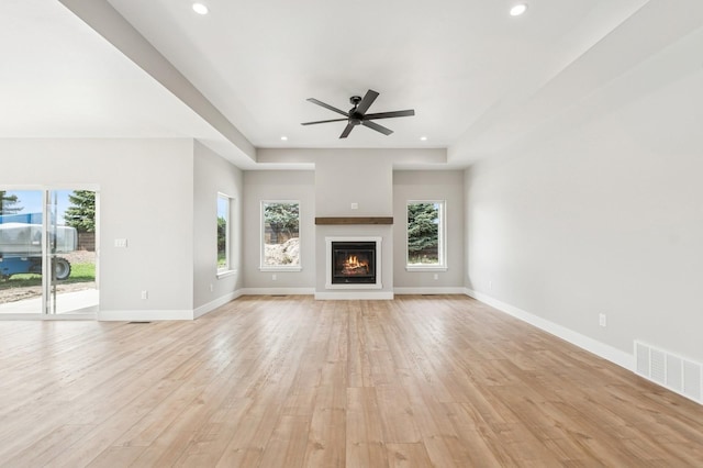 unfurnished living room featuring light wood-style floors, visible vents, and plenty of natural light