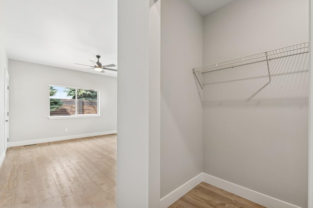 spacious closet with ceiling fan, light wood-style flooring, and visible vents