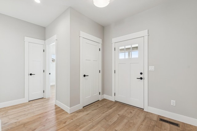 entryway with light wood-type flooring, visible vents, and baseboards
