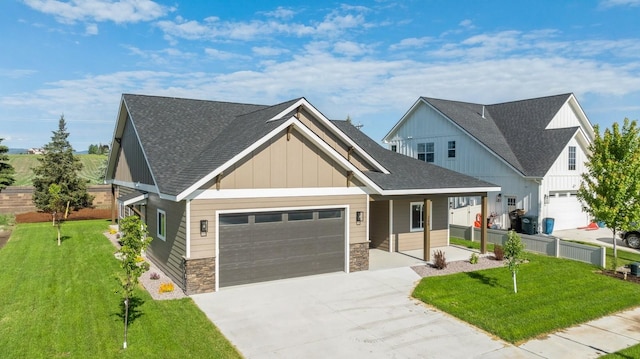 268 Landing Ln, Kalispell, MT 59901 - view of front of house with concrete driveway, an attached garage, a front lawn, and stone siding