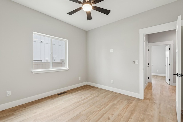 spare room with a ceiling fan, baseboards, and light wood finished floors