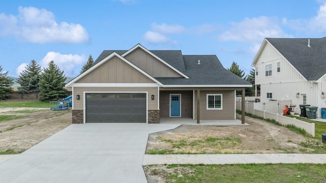 craftsman-style home featuring a porch, fence, an attached garage, driveway, and board and batten siding