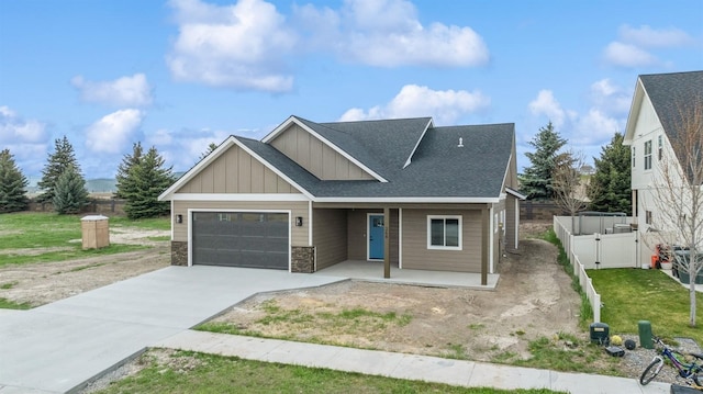 craftsman house with board and batten siding, a garage, concrete driveway, stone siding, and a porch