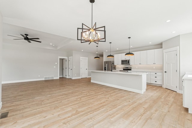 kitchen with stainless steel appliances, open floor plan, visible vents, light countertops, and recessed lighting