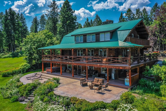 420 Deer Creek Rd, Lakeside, MT 59922 - rear view of house featuring a patio, a deck, a metal roof, and a chimney