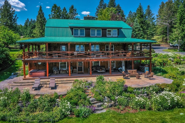420 Deer Creek Rd, Lakeside, MT 59922 - rear view of house with a hot tub, a patio area, log siding, a metal roof, and a deck