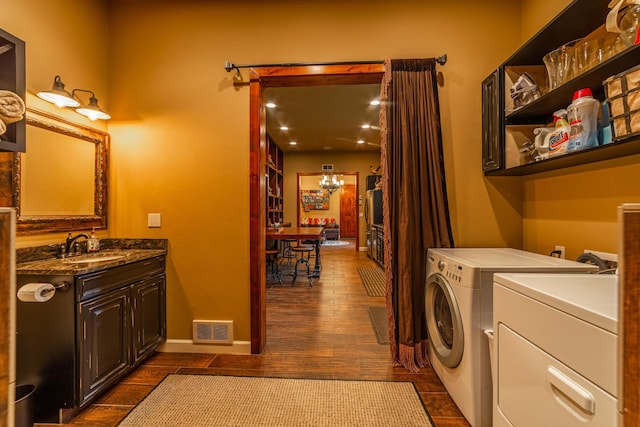 420 Deer Creek Rd, Lakeside, MT 59922 - laundry area featuring washing machine and clothes dryer, cabinet space, dark wood-type flooring, and a chandelier