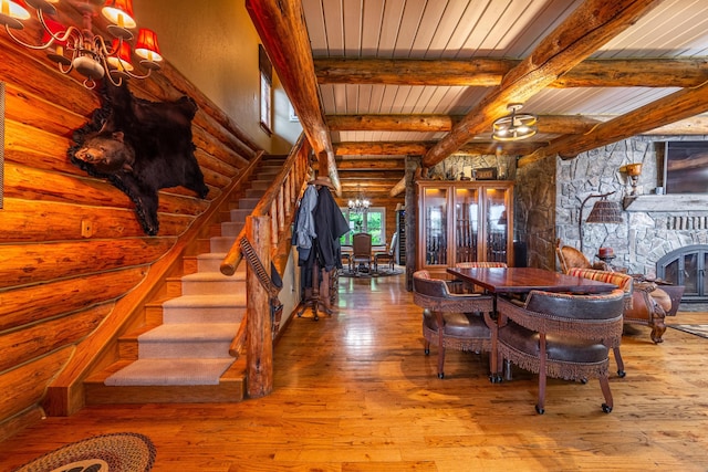 420 Deer Creek Rd, Lakeside, MT 59922 - dining area with a chandelier, stairs, wood-type flooring, a fireplace, and a wooden ceiling with exposed beams