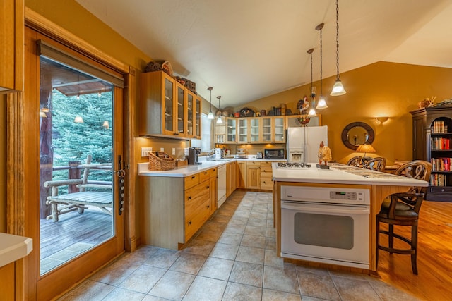 420 Deer Creek Rd, Lakeside, MT 59922 - kitchen with white appliances, lofted ceiling, light countertops, glass insert cabinets, and decorative light fixtures