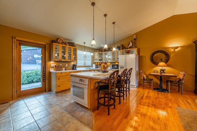 420 Deer Creek Rd, Lakeside, MT 59922 - kitchen featuring white appliances, lofted ceiling, light countertops, glass insert cabinets, and a kitchen island