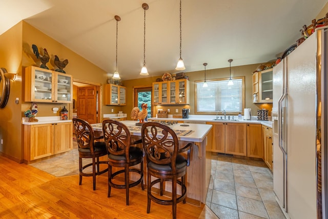420 Deer Creek Rd, Lakeside, MT 59922 - kitchen with white fridge with ice dispenser, a kitchen island, light countertops, a kitchen bar, and glass insert cabinets