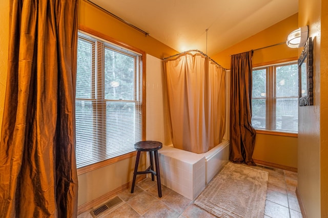 420 Deer Creek Rd, Lakeside, MT 59922 - bathroom featuring shower / bath combo, lofted ceiling, plenty of natural light, and tile patterned floors