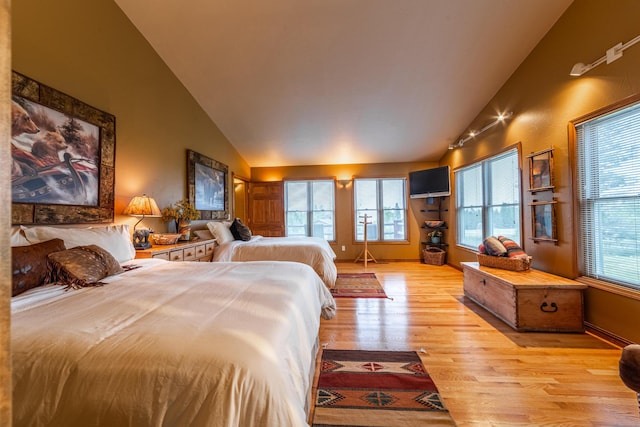 420 Deer Creek Rd, Lakeside, MT 59922 - bedroom featuring light wood-type flooring, multiple windows, and high vaulted ceiling