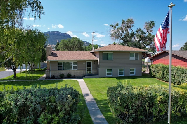 1611 Peosta Ave, Helena, MT 59601 - view of front of property featuring brick siding, a mountain view, a chimney, and a front yard