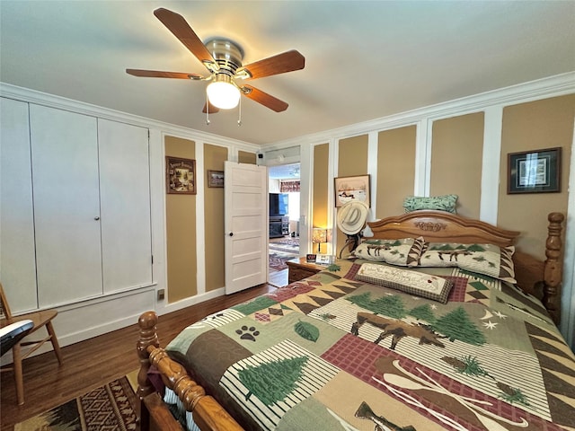 bedroom featuring a closet, crown molding, dark wood-style flooring, baseboards, and ceiling fan