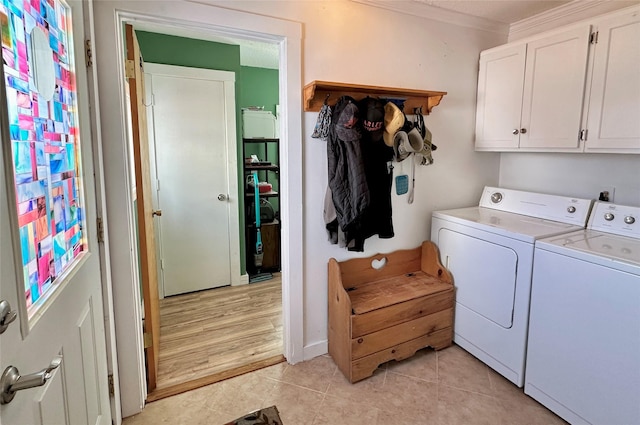 laundry area with washer and dryer, cabinet space, and light tile patterned floors