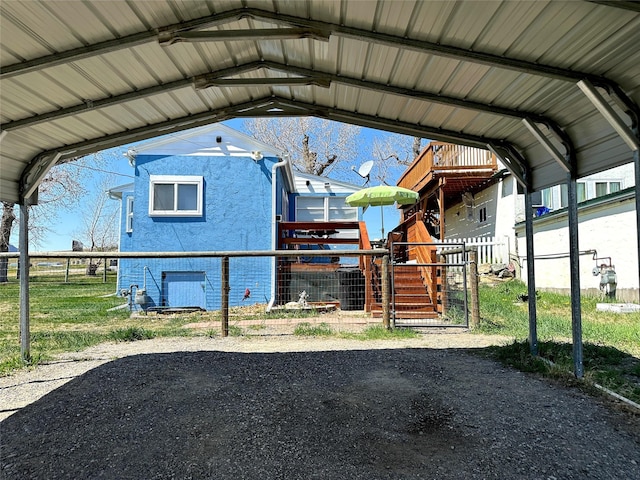 view of parking featuring fence and a carport