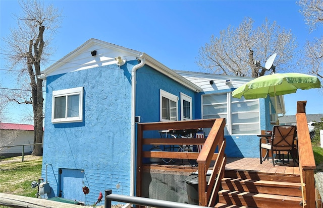 view of property exterior with a deck and stucco siding