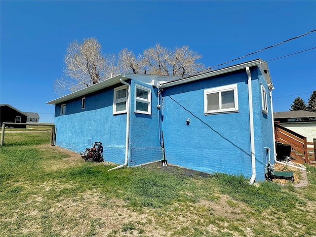 back of house featuring a yard and stucco siding