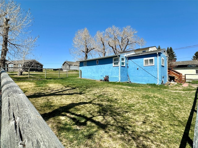 exterior space featuring fence and a lawn