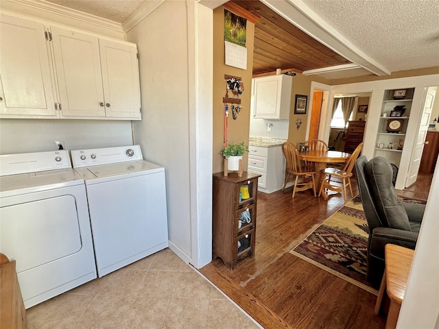 laundry room featuring ornamental molding, a textured ceiling, cabinet space, and washer and dryer