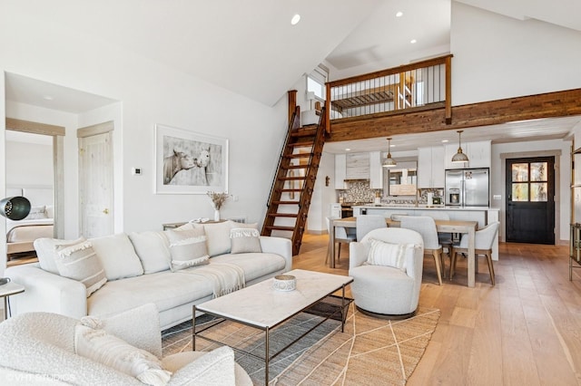 living area with stairway, recessed lighting, high vaulted ceiling, and light wood-style floors