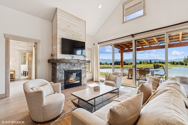 living room with a fireplace, high vaulted ceiling, plenty of natural light, and wood finished floors