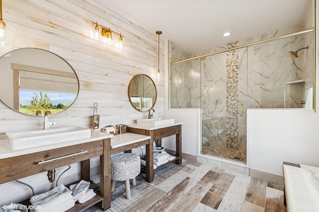 bathroom with a marble finish shower, wood finished floors, wooden walls, vanity, and recessed lighting