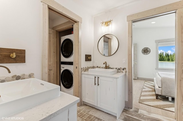 bathroom featuring stacked washing maching and dryer and vanity