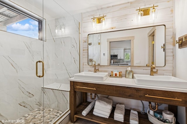 bathroom with a sink, double vanity, a wealth of natural light, and a marble finish shower