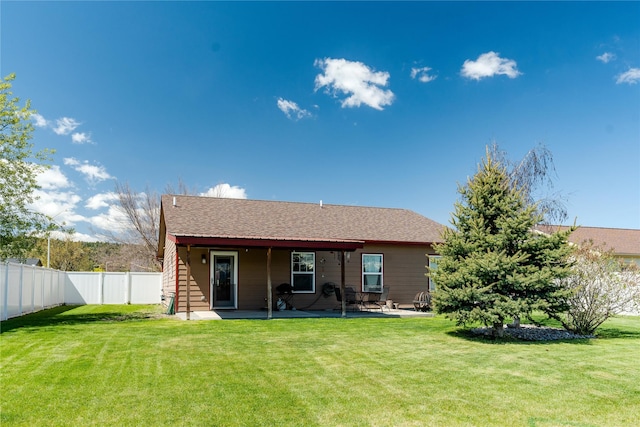 rear view of house featuring a fenced backyard, a patio, and a yard