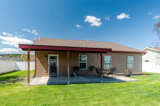 back of house featuring a fenced backyard, a patio, a shingled roof, and a yard