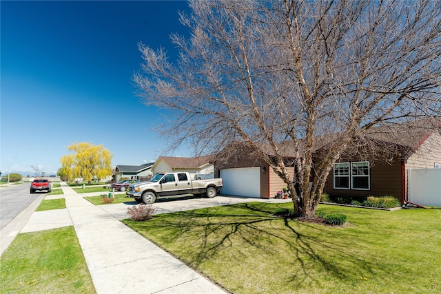 view of front of home with an attached garage, driveway, and a front yard