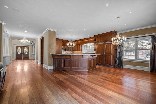 305 Columbia Ave, Whitefish, MT 59937 - kitchen featuring a chandelier, dark wood-style flooring, arched walkways, a kitchen bar, and a peninsula
