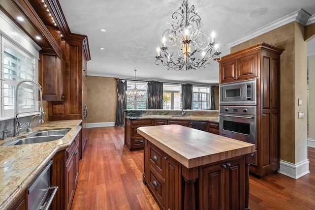 305 Columbia Ave, Whitefish, MT 59937 - kitchen featuring appliances with stainless steel finishes, butcher block counters, a chandelier, a peninsula, and a center island