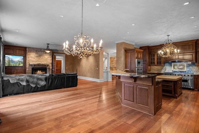 305 Columbia Ave, Whitefish, MT 59937 - kitchen featuring stainless steel appliances, a chandelier, a fireplace, a kitchen breakfast bar, and open floor plan