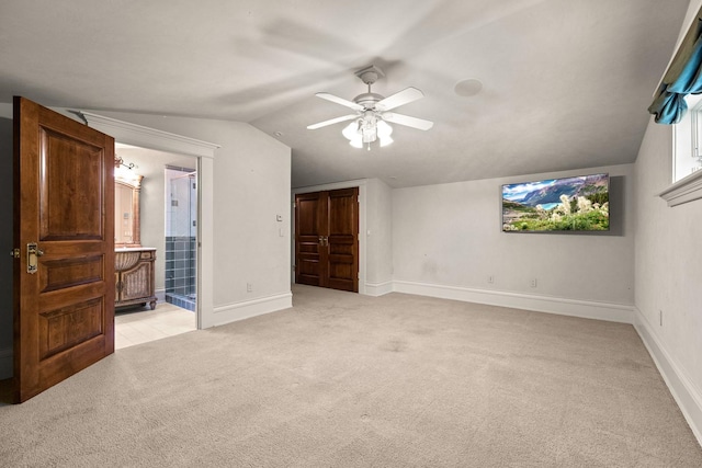 305 Columbia Ave, Whitefish, MT 59937 - unfurnished bedroom with light carpet, vaulted ceiling, ceiling fan, ensuite bath, and a closet