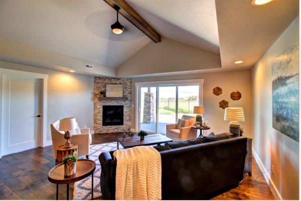 living room with recessed lighting, a stone fireplace, visible vents, wood finished floors, and lofted ceiling with beams