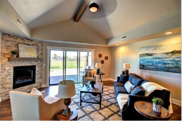 living area with baseboards, lofted ceiling with beams, visible vents, and wood finished floors