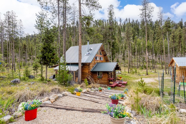 1441 Bonanza Dr, Sula, MT 59871 - view of front of property with log siding, a view of trees, and metal roof