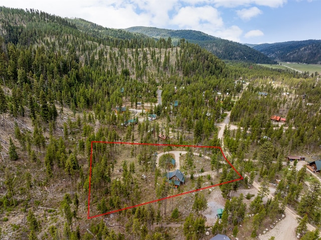 1441 Bonanza Dr, Sula, MT 59871 - aerial view of property and surrounding area featuring mountains, property parcel outlined, and a heavily wooded area