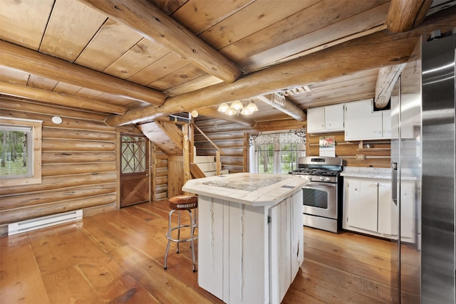 1441 Bonanza Dr, Sula, MT 59871 - kitchen with stainless steel appliances, light wood finished floors, a baseboard heating unit, white cabinetry, and rustic walls