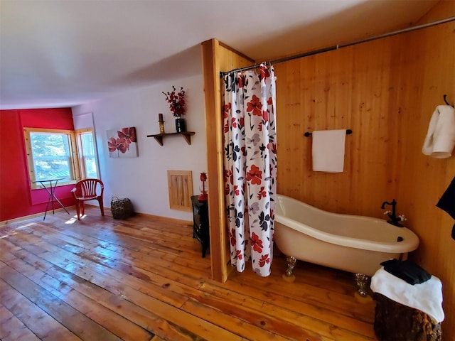 4056 Snow Fleury Ln, Lincoln, MT 59639 - bathroom featuring hardwood / wood-style flooring, a soaking tub, and a shower with curtain