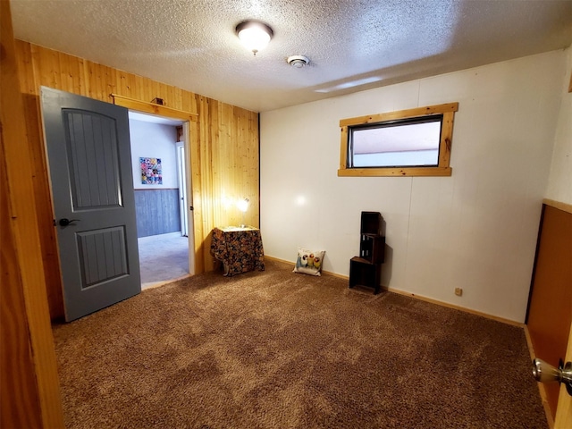 4056 Snow Fleury Ln, Lincoln, MT 59639 - unfurnished room with carpet floors, wooden walls, a textured ceiling, a smoke detector, and baseboards