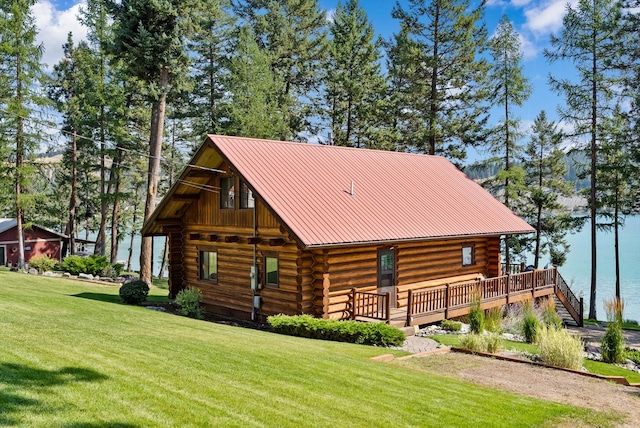 662 S Foys Lake Dr, Kalispell, MT 59901 - view of front of house with log exterior, a front yard, and a metal roof