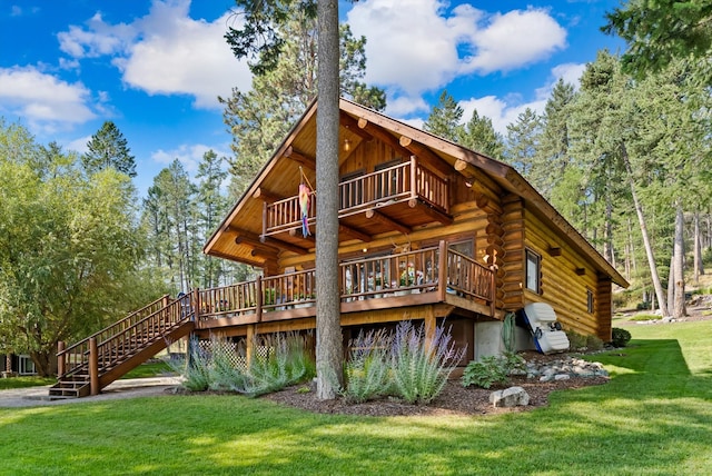 662 S Foys Lake Dr, Kalispell, MT 59901 - rear view of house with log exterior, a lawn, a wooden deck, and stairs