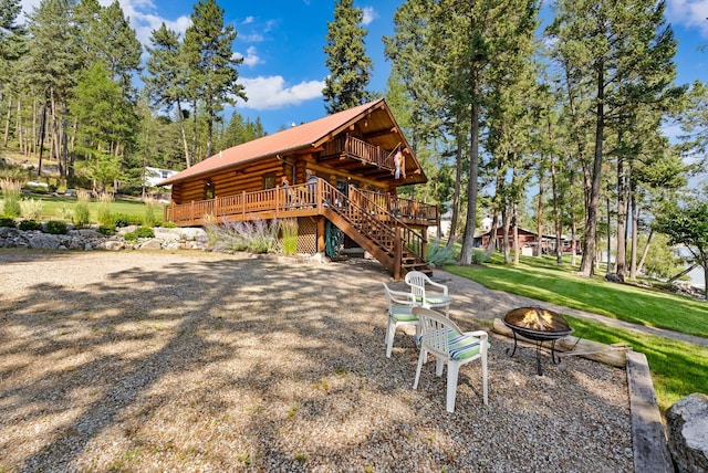 662 S Foys Lake Dr, Kalispell, MT 59901 - back of house featuring an outdoor fire pit, stairway, a deck, a metal roof, and log exterior
