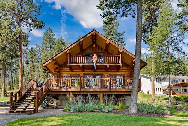 662 S Foys Lake Dr, Kalispell, MT 59901 - rear view of property with log exterior, a deck, stairway, and a yard