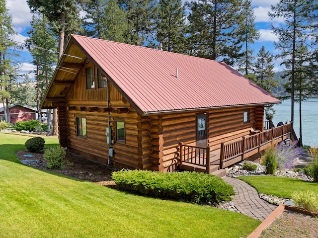 662 S Foys Lake Dr, Kalispell, MT 59901 - view of side of property with log siding, a yard, a water view, and a metal roof
